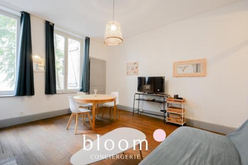 un salon avec une table et un lit dans l'établissement Nancy vieille ville Place St Epvre le 2 chambres des Dames, à Nancy