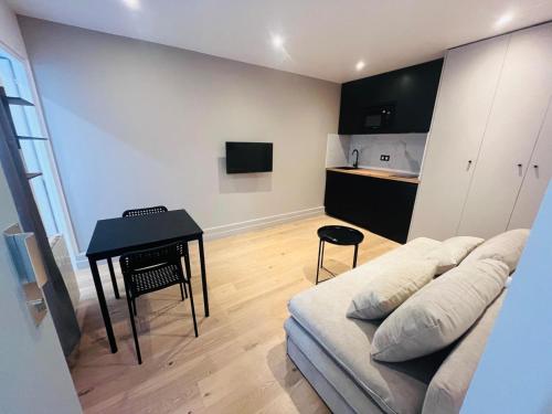 un salon avec un canapé et une table dans l'établissement Studio Heliopolis - Best Location, à Paris