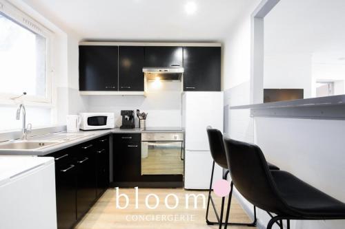 une cuisine avec des appareils blancs et des armoires noires dans l'établissement Nancy Vieille ville élégant F2 tout équipé, à Nancy