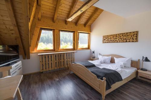 a bedroom with a bed in a room with wooden ceilings at Berghotel und Restaurant Kräuter Chalet in Furtwangen