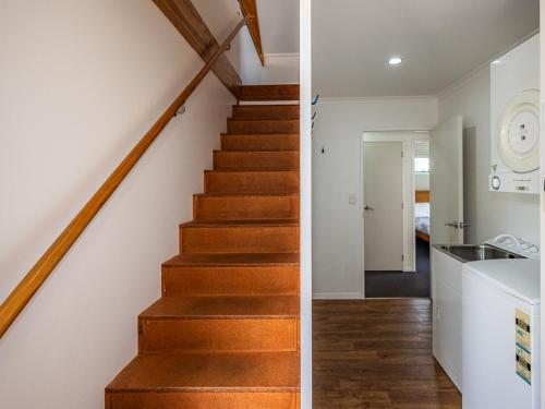 a staircase in a house with white walls and wooden floors at Willstone Chalet - Ohakune Chalet near Turoa in Ohakune
