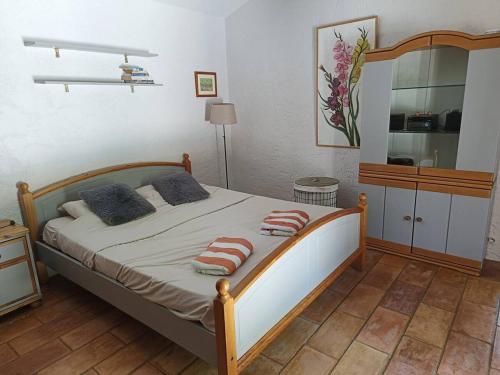una camera da letto con un letto con due cuscini sopra di Villa Provence élégante climatisée a Oppède