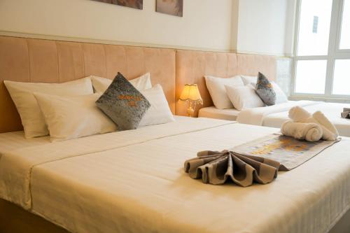 two beds in a hotel room with a large white bed at Nghia Lan Hotel in Da Lat