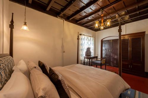 マディケーリにあるSliceinn Escapes Pushpanjali - Madikeri, Coorgの部屋にベッドとテーブルがある寝室