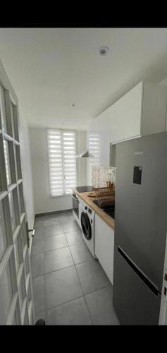 Il comprend une cuisine équipée d'un réfrigérateur et d'une cuisinière. four supérieur dans l'établissement Appartement cosy à Saint-Denis, 35 m², pour 4 personnes, à Saint-Denis