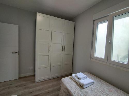 a bedroom with a bed with two towels on it at Oktheway Corme in Corme-Puerto