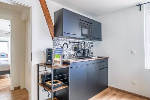 - une cuisine avec des placards bleus et un four micro-ondes dans l'établissement Ostwald - Tram à 4min et 20min du centre de Stras - Confort familial, à Ostwald