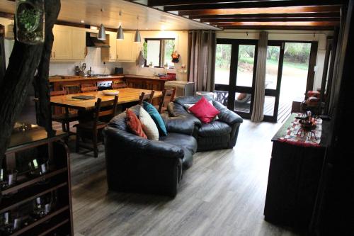 a living room with couches and a table and a kitchen at House On Blyde in Kampersrus AH