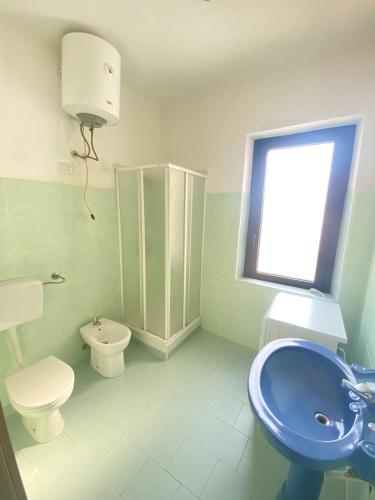 a bathroom with a sink and a toilet and a window at Casa Passeri in San Teodoro