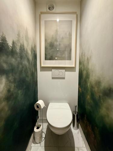 a bathroom with a toilet and a painting on the wall at Appt Rénové et Moderne - 3 chambres - Châtel - Multi Pass - MÉNAGE INCLUS in Châtel