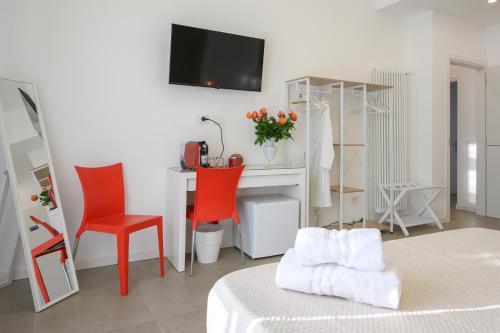 a room with a desk and a bed with red chairs at La Cattedrale in La Spezia