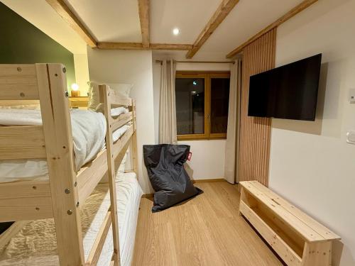 a room with two bunk beds and a flat screen tv at Appt Rénové et Moderne - 3 chambres - Châtel - Multi Pass - MÉNAGE INCLUS in Châtel
