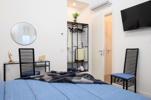 a bedroom with a blue bed and two chairs at La Cattedrale in La Spezia