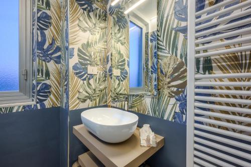 a bathroom with a white sink and blue and white wallpaper at La Cattedrale in La Spezia