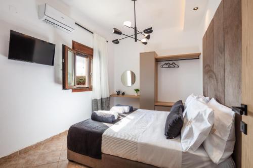 a bedroom with a bed and a flat screen tv at Villa Red Sunset by Estia in Sfakaki