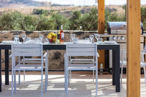 a table with glasses of wine on a patio at Villa Red Sunset by Estia in Sfakaki