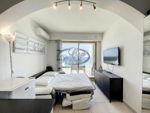 une chambre avec un lit et une télévision dans l'établissement studio pieds dans leau vue mer pour 2 personnes plage de cavaliere, au Lavandou
