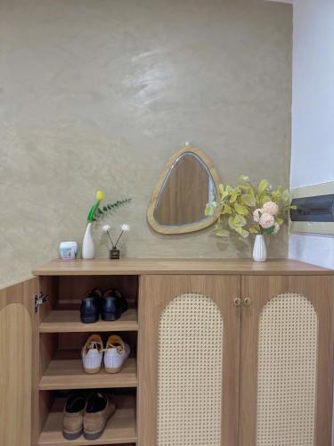a dressing table with a mirror and some shoes at Nera home, An apartment Huế in Thôn Văn Dương