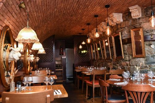 un restaurant avec des tables, des chaises et des lustres en bois dans l'établissement Hotel K'Loys, à Paimpol