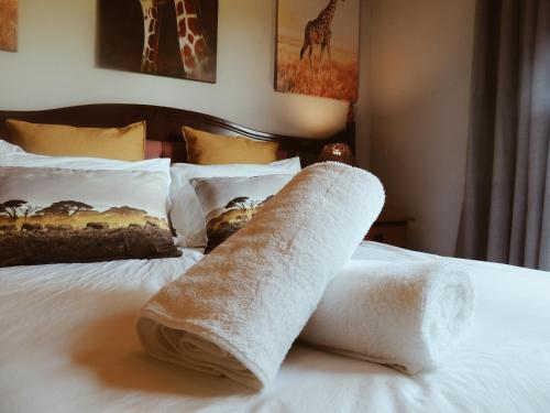 a towel sitting on top of a bed at The Wild Olive Sanctuary Accommodation in Paterson