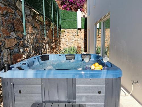 a bath tub with wine glasses and a bowl of fruit at Charming Villa with a Pool in Alanya