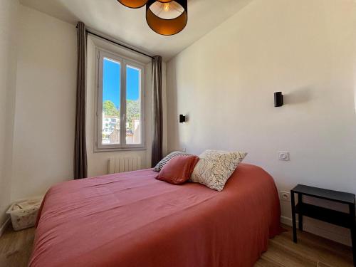 une chambre avec un lit avec une grande fenêtre dans l'établissement Deux pièces de charme - Centre ville, au Cannet
