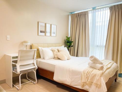 a bedroom with a bed with a chair and a window at 1BR Condo, BGC Uptown Mall, Grand Hyatt #ournw20j in Manila