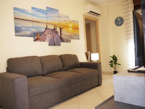 una sala de estar con un sofá marrón en una habitación en Modern Two-Bedroom Flat, 10 Mins Walk To The Beach, en Quartu SantʼElena