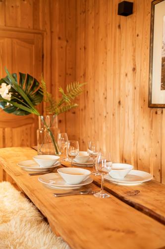 a wooden table with plates and wine glasses on it at Miętowa Osada Czerwienne in Ciche