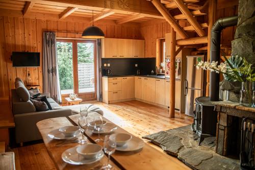 a living room with a table and a kitchen at Miętowa Osada Czerwienne in Ciche