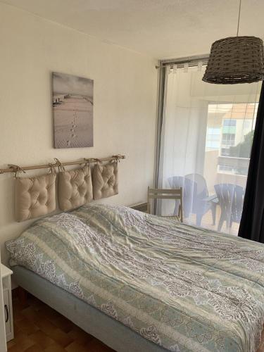 une chambre avec un lit, une fenêtre et une table dans l'établissement Sol-y-Days Floralies, grand duplex 6 personnes proche des plages, au Grau-du-Roi