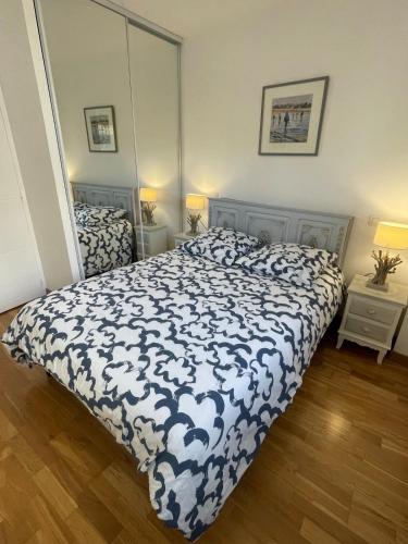 a bedroom with a bed with a blue and white comforter at Chaleureux appartement sur Brest in Brest