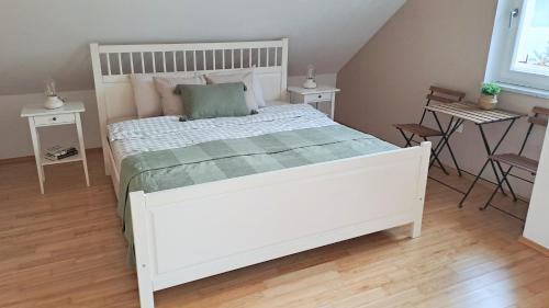 a white bed in a bedroom with two tables at HomeSlovenia - your Home in the Heart of Slovenia in Selca