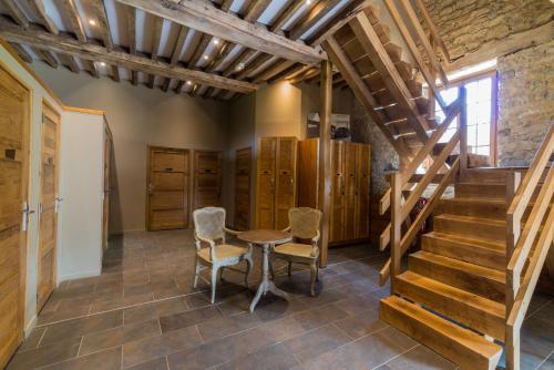 a room with a wooden staircase and a table and chairs at Domaine de la Pommeraye & Spa in La Pommeraye