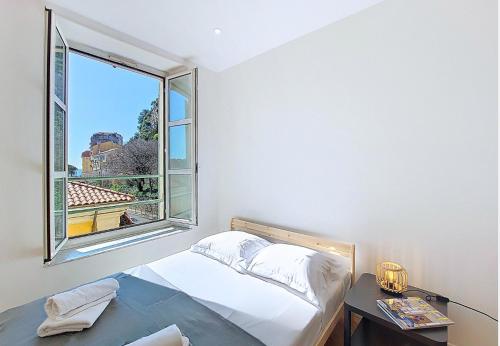 une chambre avec un lit et une grande fenêtre dans l'établissement Nestor&Jeeves - STUDIO DU PORT - Central, à Nice