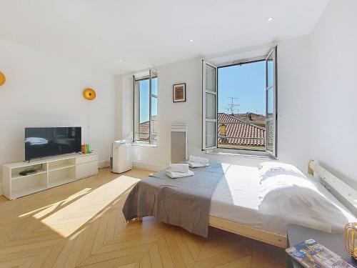 une chambre avec un grand lit et une grande fenêtre dans l'établissement Nestor&Jeeves - STUDIO DU PORT - Central, à Nice