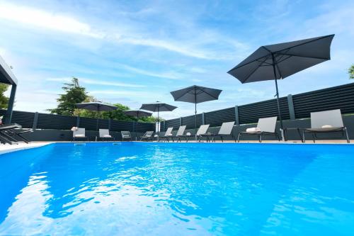 a swimming pool with chairs and umbrellas at Apartments with private jacuzzi Garbin 1 and Garbin 2 in Rovinj