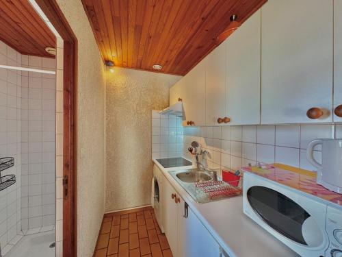 une cuisine avec un évier et une machine à laver dans l'établissement Rouge Gorge - Studio à 500m des plages, à Mimizan-Plage