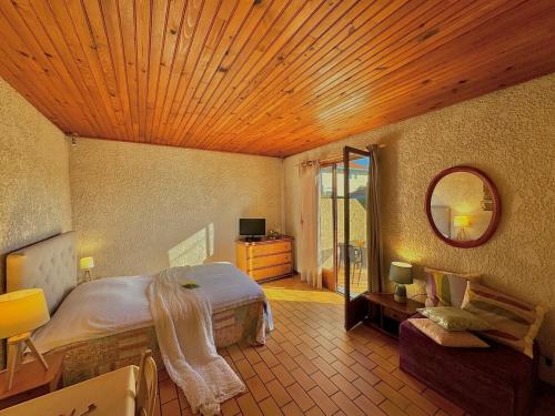 une chambre avec un grand lit et un miroir dans l'établissement Rouge Gorge - Studio à 500m des plages, à Mimizan-Plage