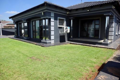 a house with a lawn in front of it at KwaZikode Guesthouse in Meyerton