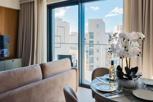 a living room with a couch and a table at Mercury Suite Bright w Pool access by Arco Collection in St. Julianʼs