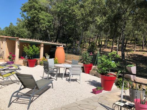 un patio avec une table, des chaises et des plantes dans l'établissement Welcome to La Maison du bonheur, à Vidauban