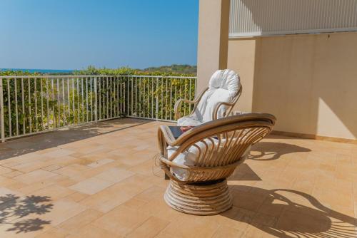 a person sitting in a chair on a balcony at Donnalucata Suite in Donnalucata