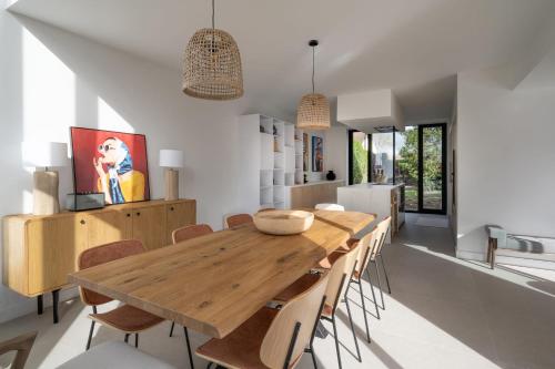 une salle à manger avec une table et des chaises en bois dans l'établissement Villa Bellevie - Welkeys, à Magny-le-Hongre