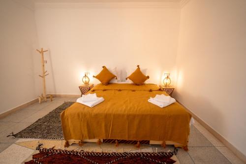 a bedroom with a bed with two lamps on it at Dasofinya lodges in Touggana
