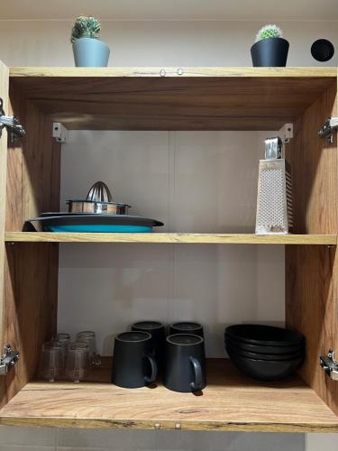 a wooden shelf with pots and pans on it at Grange Des Rêves in Lichtenberg