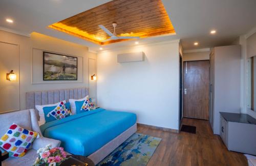 a bedroom with a blue bed and a couch at Perfectstayz Premium Westend at Mall Road in Mussoorie