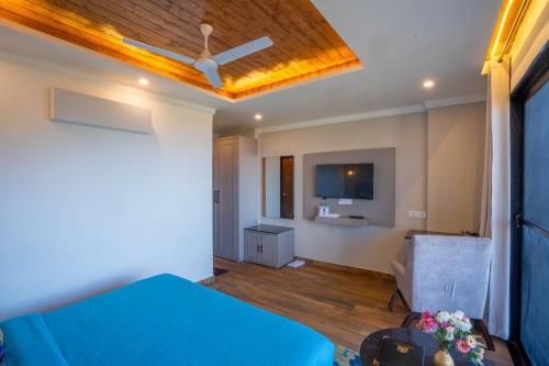 a bedroom with a blue bed and a ceiling fan at Perfectstayz Premium Westend at Mall Road in Mussoorie