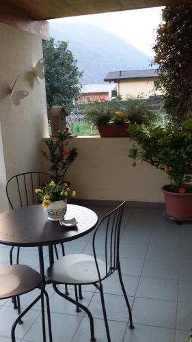 a table and two chairs on a balcony with flowers at B&B Il Vigneto in Melano