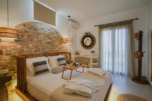 a bedroom with a bed and a stone wall at Onar Sifnos Stone Villa in Sifnos